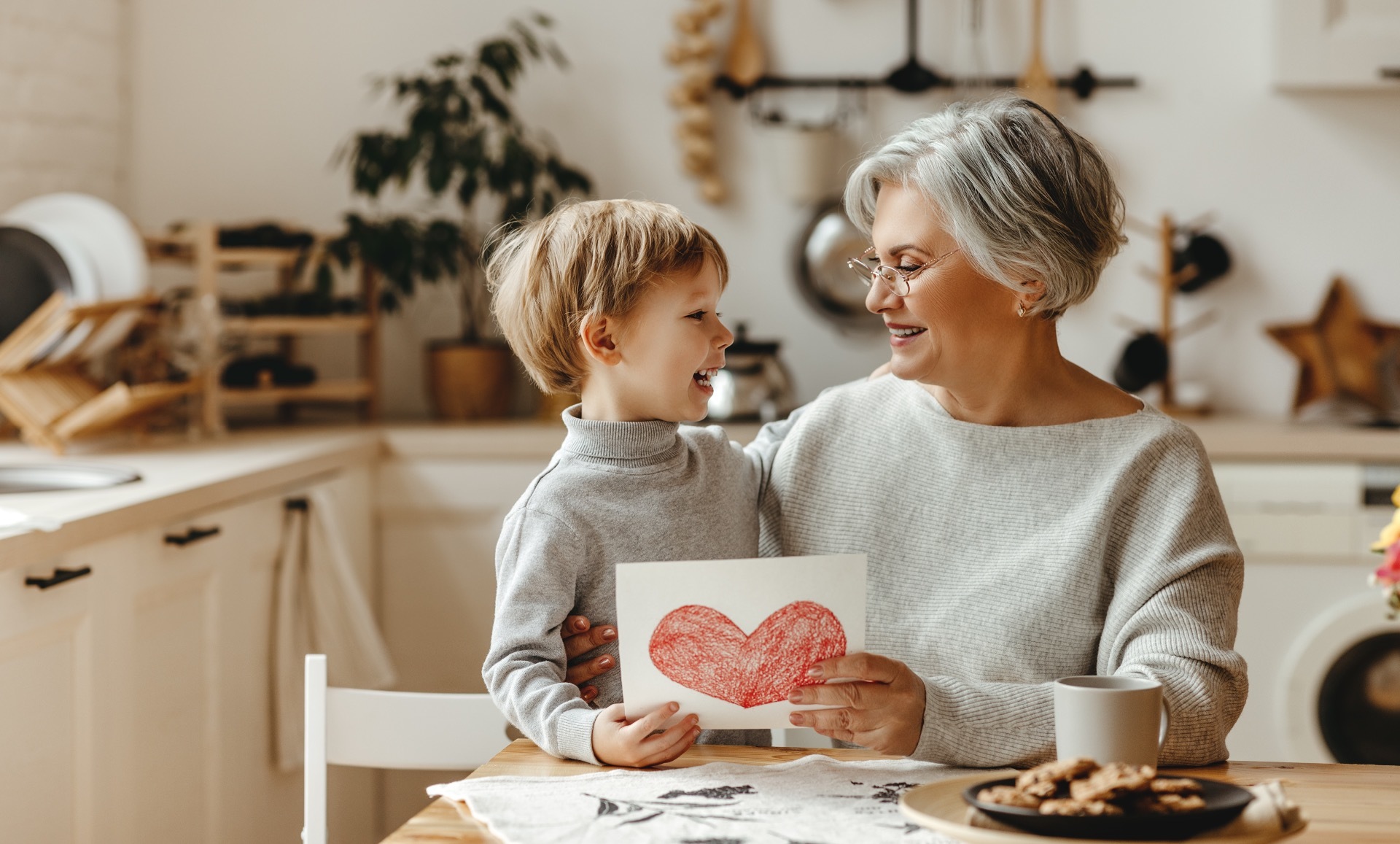 A person holding a child on their lap, with a hand-drawn heart drawing in their hands; our Wills Solicitors in Preston discuss the importance of a Will.